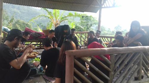 a group of people sitting around a table eating food at De Salak Homestay in Bogor