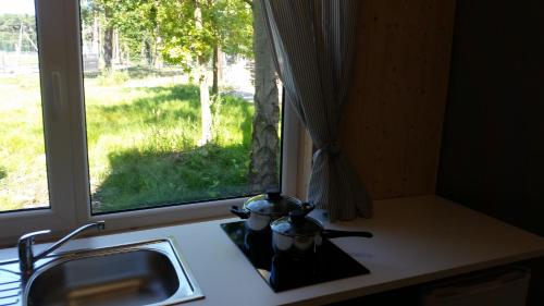 encimera de cocina con fregadero y ventana en Domki Aqua Holiday, en Pobierowo