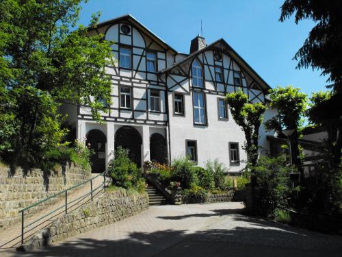 a large white house with a black and white building at Panoramahotel Wolfsberg in Bad Schandau