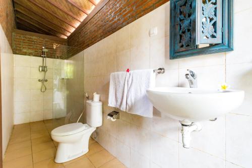 a bathroom with a sink and a toilet at Arton Resort & Beach Club in Pulukan