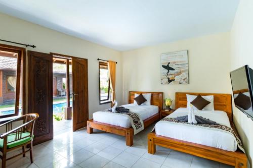 1 dormitorio con 2 camas, mesa y sillas en Arton Resort & Beach Club, en Pulukan