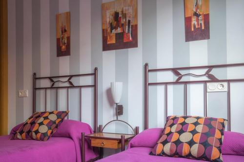 a living room with a purple couch and a bed at Apartamento Sella y Mar - VUT12AS in Ribadesella