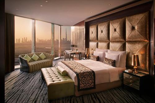 um quarto com uma cama grande e uma janela grande em The Meydan Hotel Dubai em Dubai