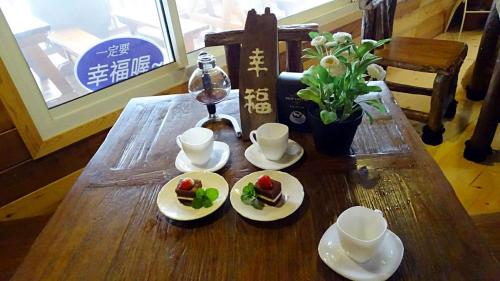 a wooden table with two plates of food on it at 幸福檜木屋民宿 in Gukeng