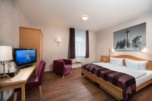 a hotel room with a bed and a desk at Best Western Plus Hotel Willingen in Willingen