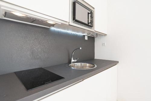 a kitchen counter with a sink and a window at Estudio Playa Candado in Málaga
