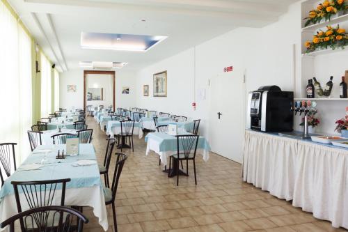 una fila de mesas y sillas en un restaurante en Hotel Nevia, en Cervia