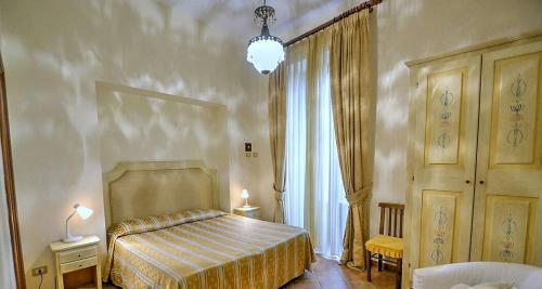 a bedroom with a bed and a lamp and a window at Divina House B&B in Sorrento