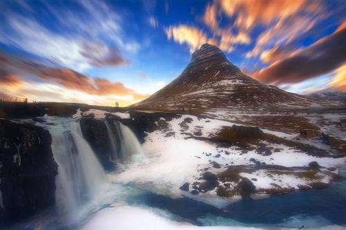 a picture of a waterfall and a mountain with snow at Við Hafið Guesthouse in Ólafsvík