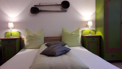 a bedroom with a bed with two night stands and two lamps at Casa Mosului - Transfăgărășan Bed & Breakfast in Cîrţişoara