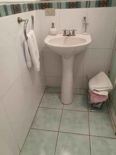 グアテマラシティにあるCasa familiar La Arboledaのタイルフロアの白いバスルーム(シンク付)