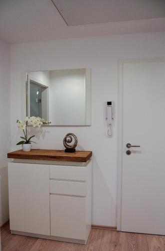 a white bathroom with a mirror and a white door at Tannenblick-Franken in Egloffstein