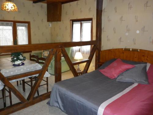 a bedroom with a bed and a table and windows at Gites Petermann in Marckolsheim