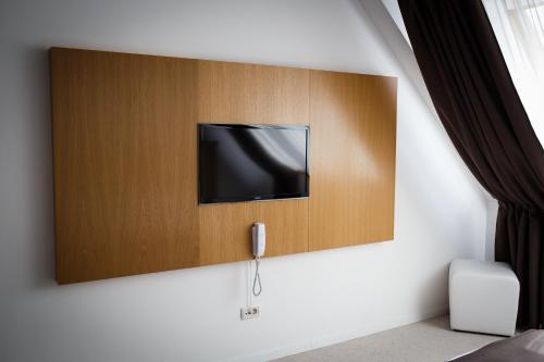 a flat screen tv on a wall in a room at Pensiunea Art 1000 in Lunca Vişagului