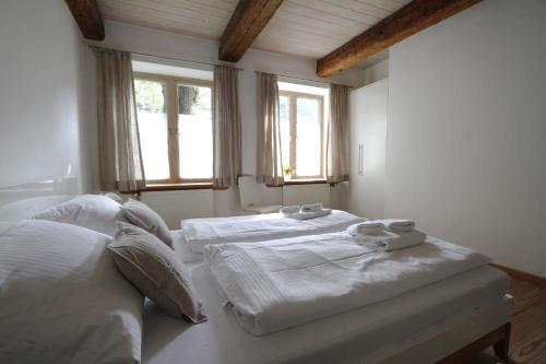 1 dormitorio con 2 camas y 2 ventanas en Ferienwohnung Suederbootfahrt, en Katingsiel