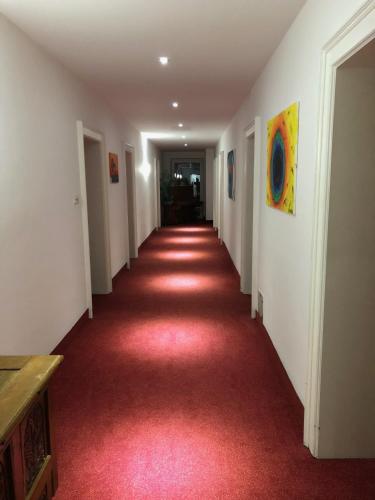 a long hallway with red carpet and white walls at Hotel Vogelweiderhof in Salzburg