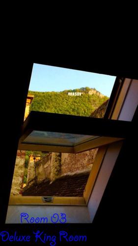 a window in a building with a view of a mountain at 4 Rooms Piata Sfatului in Braşov