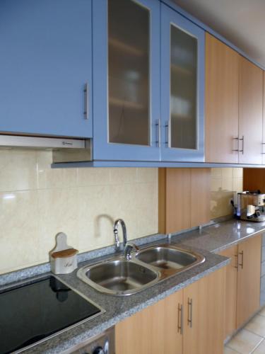 a kitchen with a sink and blue cabinets at Near Beach Apartment in Póvoa de Varzim