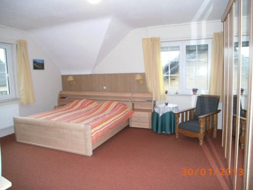 a bedroom with a bed and a desk and window at B&B De Boerderij in Berdorf