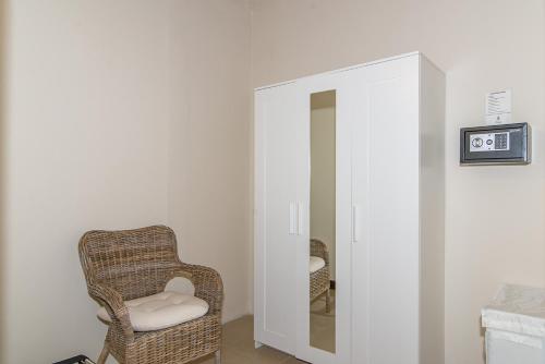 a wicker chair in a room with a mirror at Family Complex beside Beach w/Pool Montego Bay #2 in Montego Bay