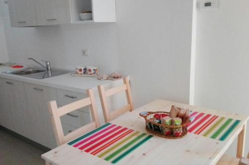 una cocina con una mesa con una cesta de fruta. en Casa Le Cementine en Verbania