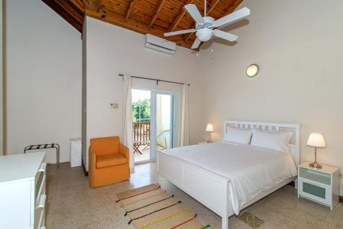 sypialnia z białym łóżkiem i wentylatorem sufitowym w obiekcie Luxury 2BR Home facing Beach w/Pool Montego Bay #3 w mieście Montego Bay