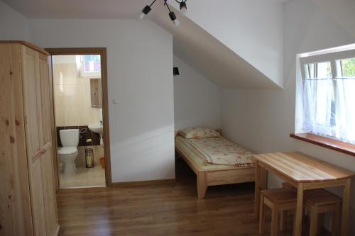 a small room with a bed and a bathroom at Sielski Zakątek in Cisna