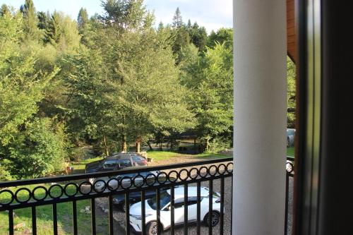a balcony with a car parked in a parking lot at Sielski Zakątek in Cisna
