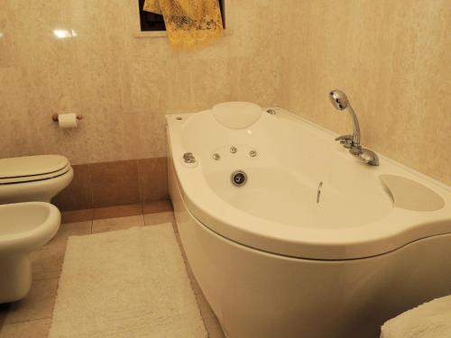 a bathroom with a bath tub next to a toilet at B&B Renè in Pescantina