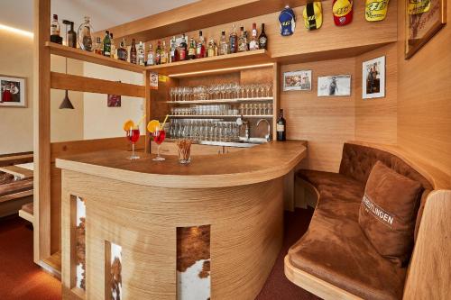a bar in a room with a couch and a chair at Garni Reutlingen in Colfosco