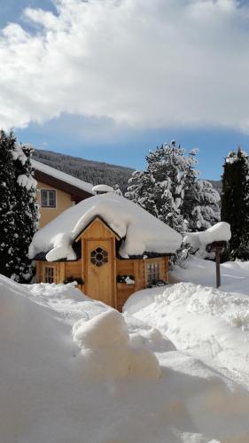 a cabin covered in snow in front of a house at Haus Anni in Radstadt