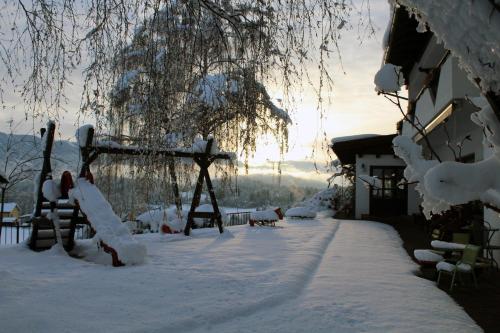 a yard covered in snow next to a house at Hotel Sonnenhof in Klagenfurt