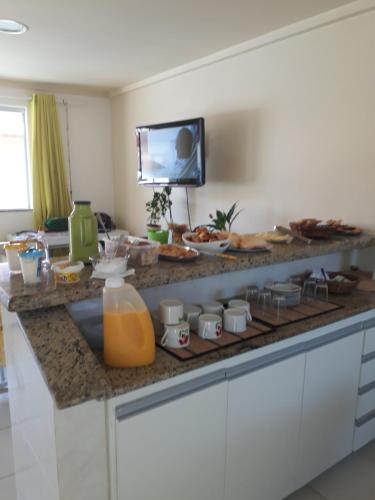 Guest House Paraiso Pataxos في بورتو سيغورو: طاولة مطبخ مع الكثير من الطعام عليها