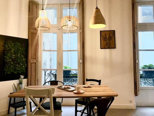 une salle à manger avec une table et des chaises en bois dans l'établissement Magnifiques Appartements Hyper Centre, à Nantes