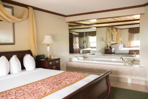 a hotel room with a bed and a bath tub at The Carlton Lodge in Adrian