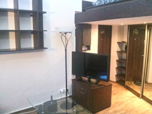 ein Wohnzimmer mit einem TV und einem Glastisch in der Unterkunft Old Wine House in Klaipėda