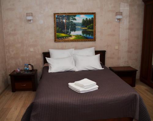 a bedroom with a bed with a picture on the wall at Centralnyi hotel in Poltava