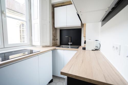 een keuken met witte kasten en een spoelbak bij Doyenné Vieux Lyon in Lyon