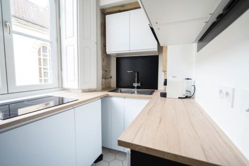 a kitchen with white cabinets and a sink at Doyenné Vieux Lyon in Lyon
