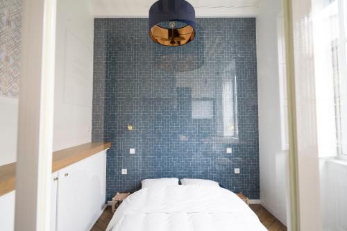 een slaapkamer met een bed en een blauwe tegelmuur bij Doyenné Vieux Lyon in Lyon
