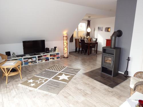 a living room with a wood stove and a dining room at Kranichnest in Hohwacht