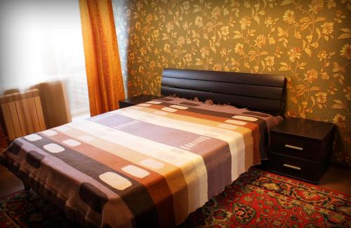 ビイスクにあるАпартаменты "Добрые Сутки" на Советской 214の壁紙のベッドルーム1室(ベッド1台付)