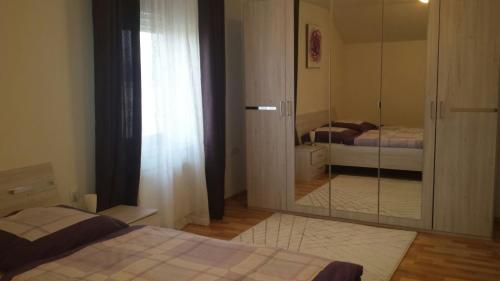 a bedroom with a mirror and two beds in it at Apartma Rodica in Domžale