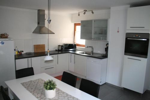 a kitchen with white cabinets and a table with a potted plant at Odas Feriendomizil in Kappel-Grafenhausen