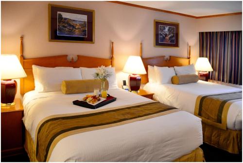 a hotel room with two beds and two lamps at The Hospitality Inn in Port Alberni