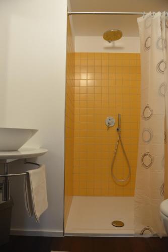 a bathroom with a shower with a yellow tile at Biker's Wine House in Rovereto