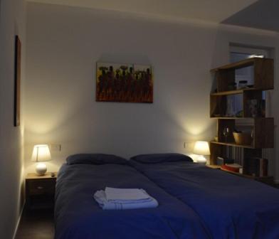 a bedroom with a blue bed and two lamps at Biker's Wine House in Rovereto