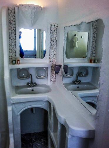 a bathroom with two sinks and two mirrors at Giannakas Studios in Platis Yialos Sifnos