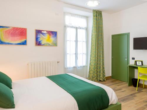 um quarto com uma cama, uma secretária e uma janela em La nostra casa in centro em Lecco