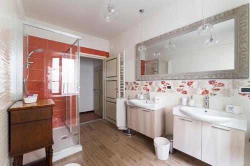 a bathroom with two sinks and a shower and a mirror at Appartamento La Terrazza in Lucca